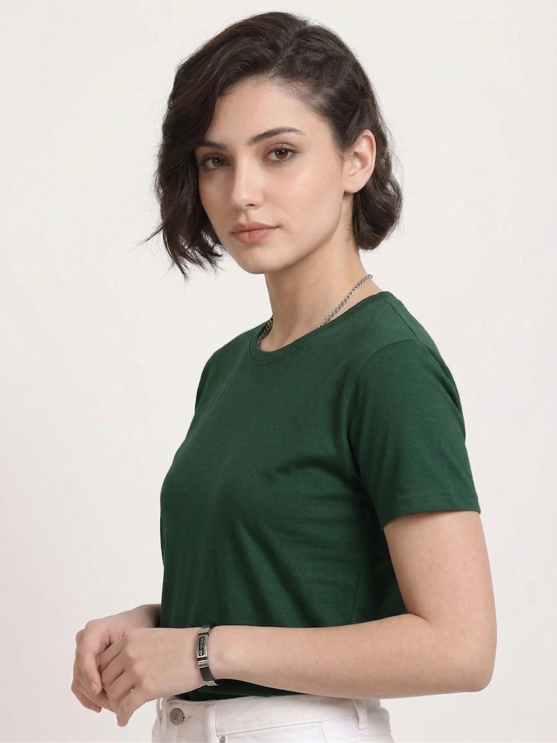 Woman wearing a t-shirt with side view in bottle green 