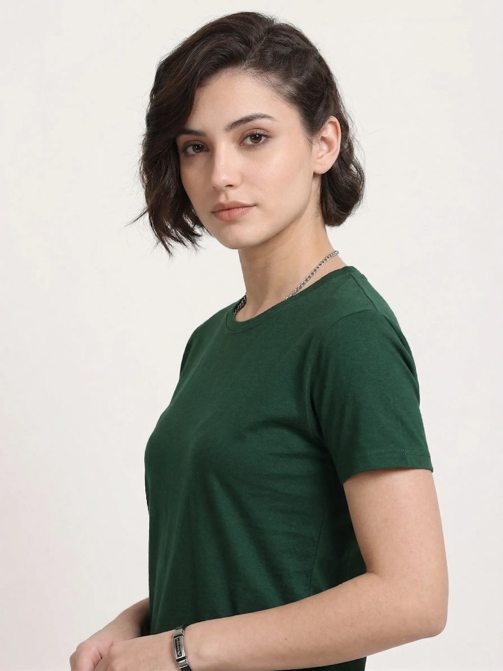 Woman wearing a t-shirt with side view in bottle green 